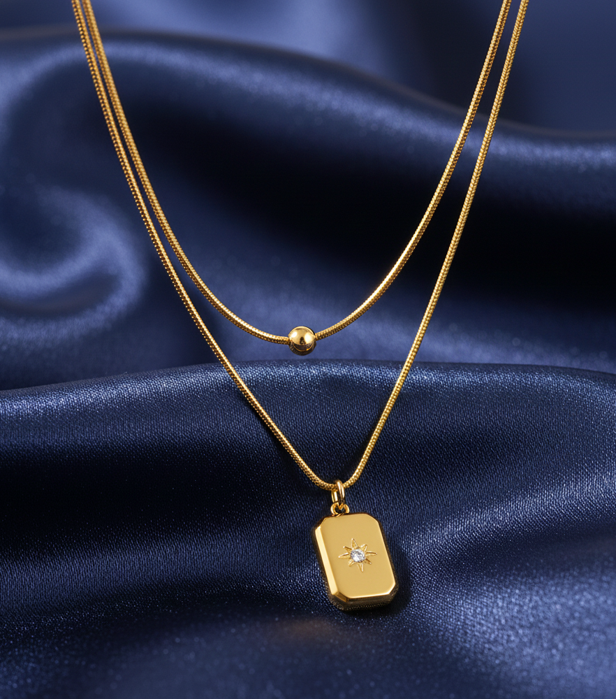 Gold necklace with a pendant on a blue satin background