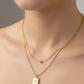 Gold necklace with a pendant on a neutral background