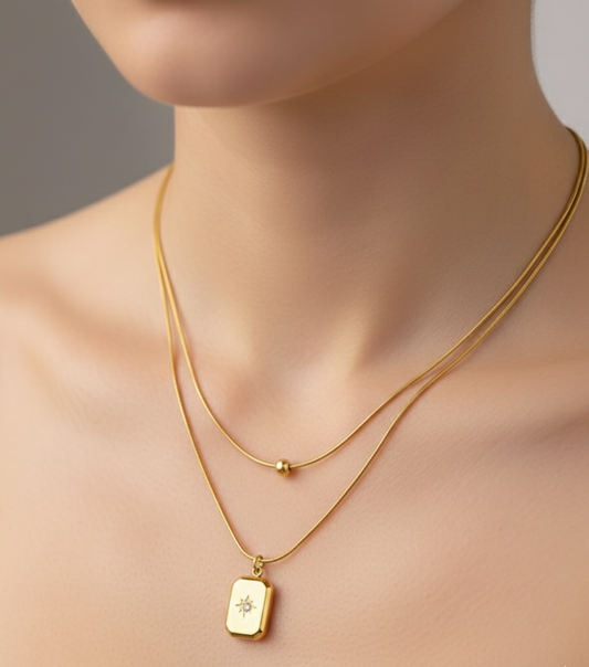 Gold necklace with a pendant on a neutral background